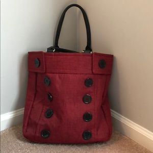 Red canvas handbag. Button accents. Metal feet.